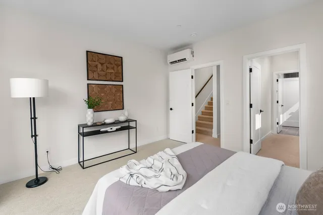 a bedroom with a bed and a potted plant on the dresser