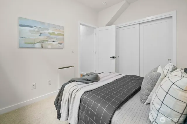 a bedroom with a bed and painting on the wall