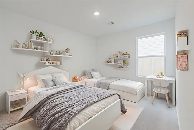 a bedroom with two beds and a table chair