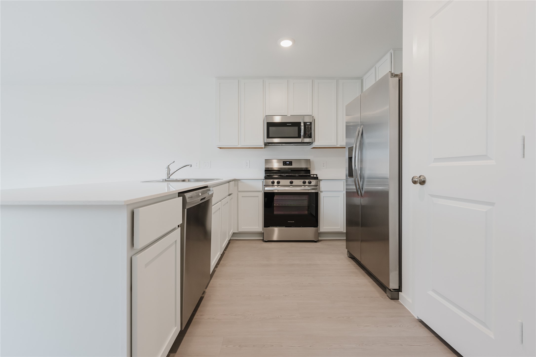 16626 Trembling Aspen Lane New Caney, TX 77357 - Photo 6 of 10 a kitchen with cabinets stainless steel appliances and sink