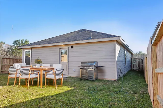 a backyard of a house with table and chairs