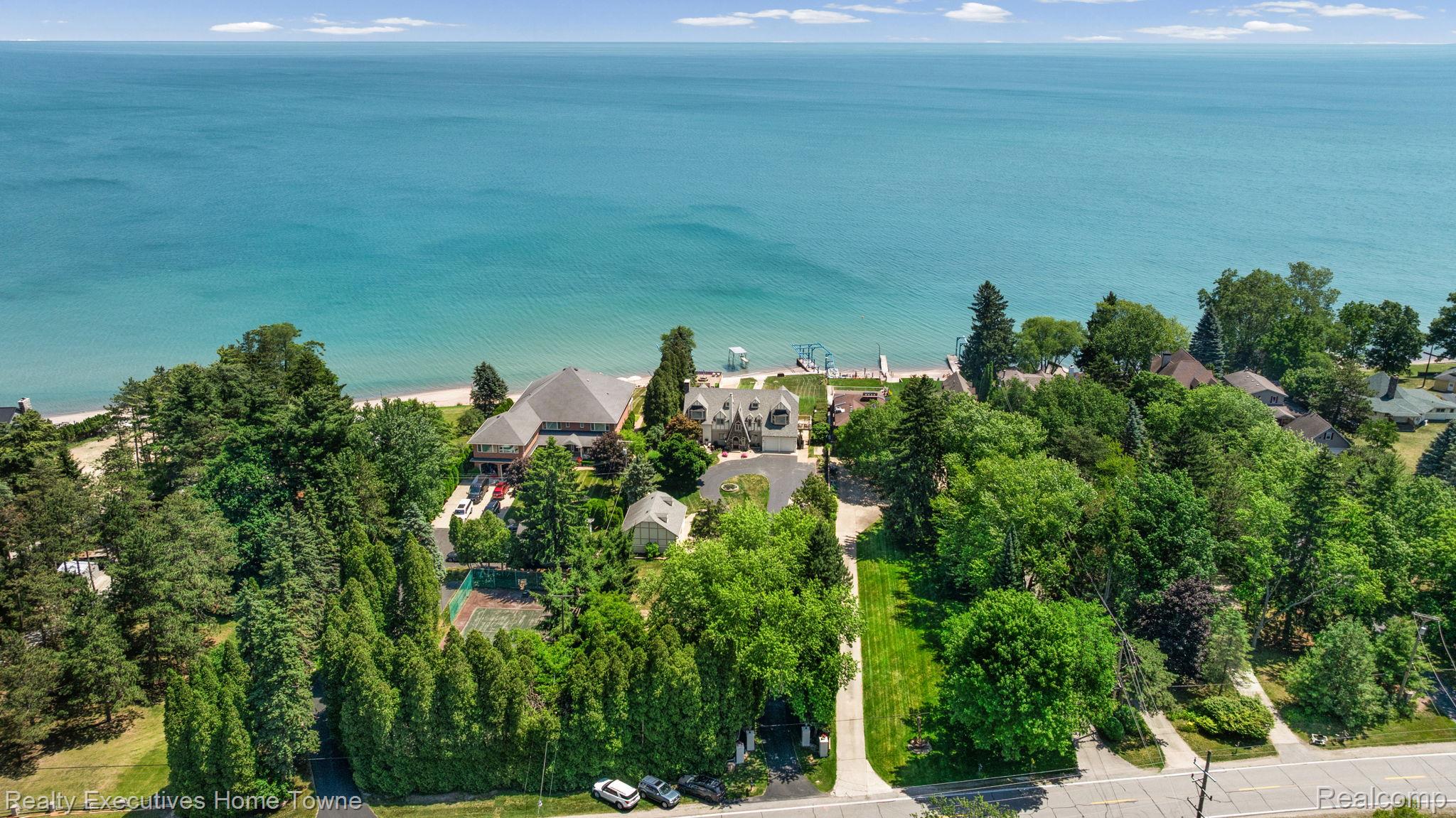 8308 Lakeshore Road Fort Gratiot, MI 48059 - Photo 25 of 79 Waterfront property featuring a private beach, mature trees, a tennis court, and paved driveways