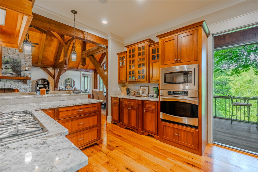 102 State Rd S-39-143 Sunset, SC 29685 - Photo 20 of 47 This spacious kitchen, featuring a kitchen island, offers a harmonious blend of culinary function and rustic architectural elements.