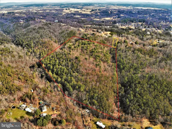 an aerial view of residential house with parking and yard