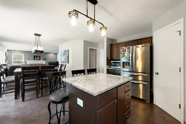 a kitchen with a refrigerator a sink and chairs