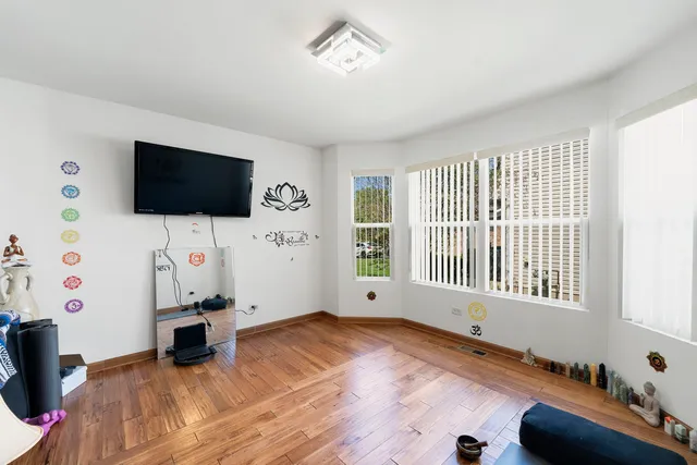 a view of a livingroom with a flat screen tv wooden floor and a window