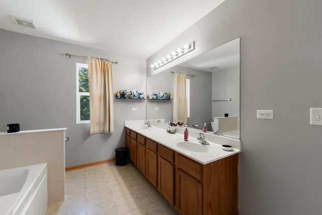 a bathroom with a tub sink and mirror