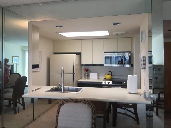 a kitchen with a dining table chairs and refrigerator