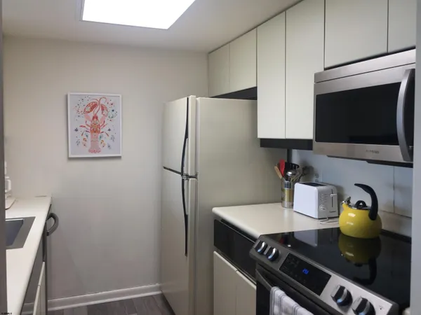 a kitchen with a refrigerator and a stove top oven