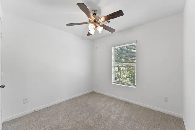 an empty room with closet and windows