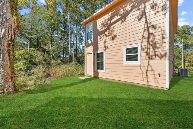 a view of a backyard with potted plants and large tree