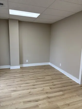 a view of an empty room with wooden floor