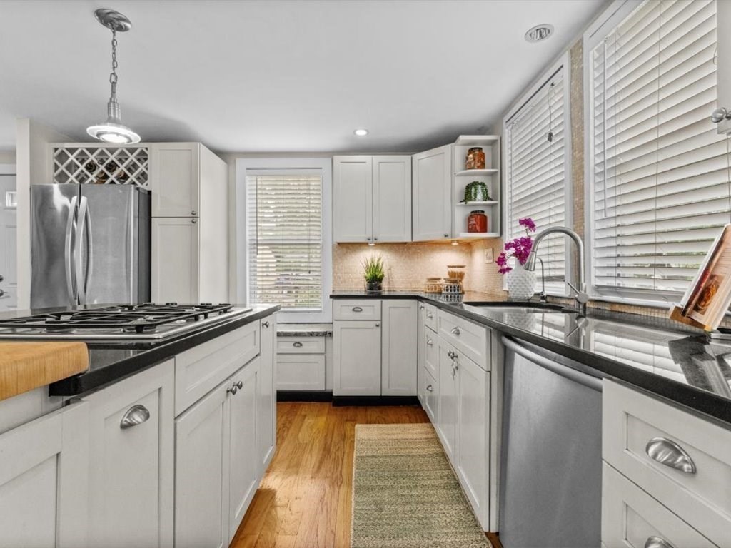 39 Evergreen Road Natick, MA 01760 - Photo 7 of 36 a kitchen with kitchen island granite countertop a sink stove and cabinets