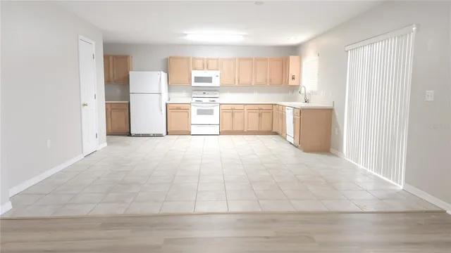 a large white kitchen with cabinets and a refrigerator