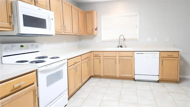 a kitchen with granite countertop white cabinets and white appliances