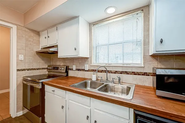 a kitchen with stainless steel appliances granite countertop a sink a stove and a microwave