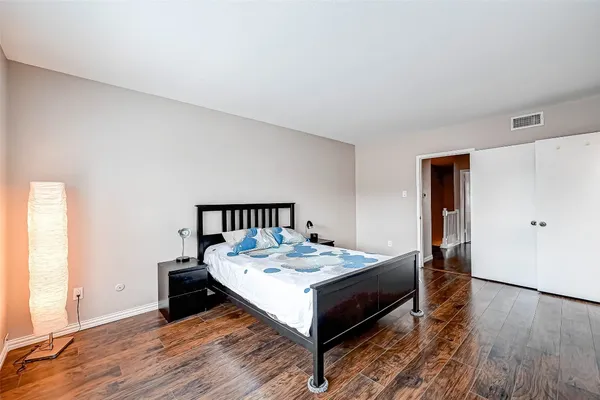 a bed sitting in a bedroom next to a window with wooden floor