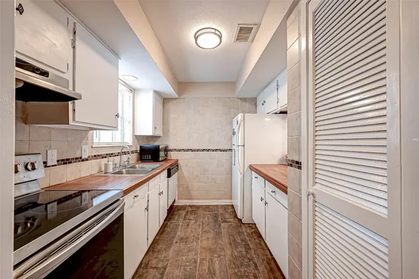 a kitchen with a sink a stove and cabinets