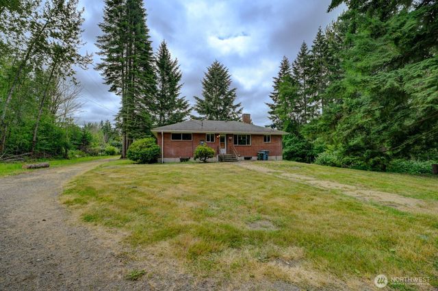 a front view of a house with yard and green space