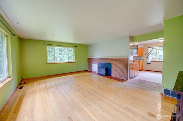 a view of empty room with kitchen and window