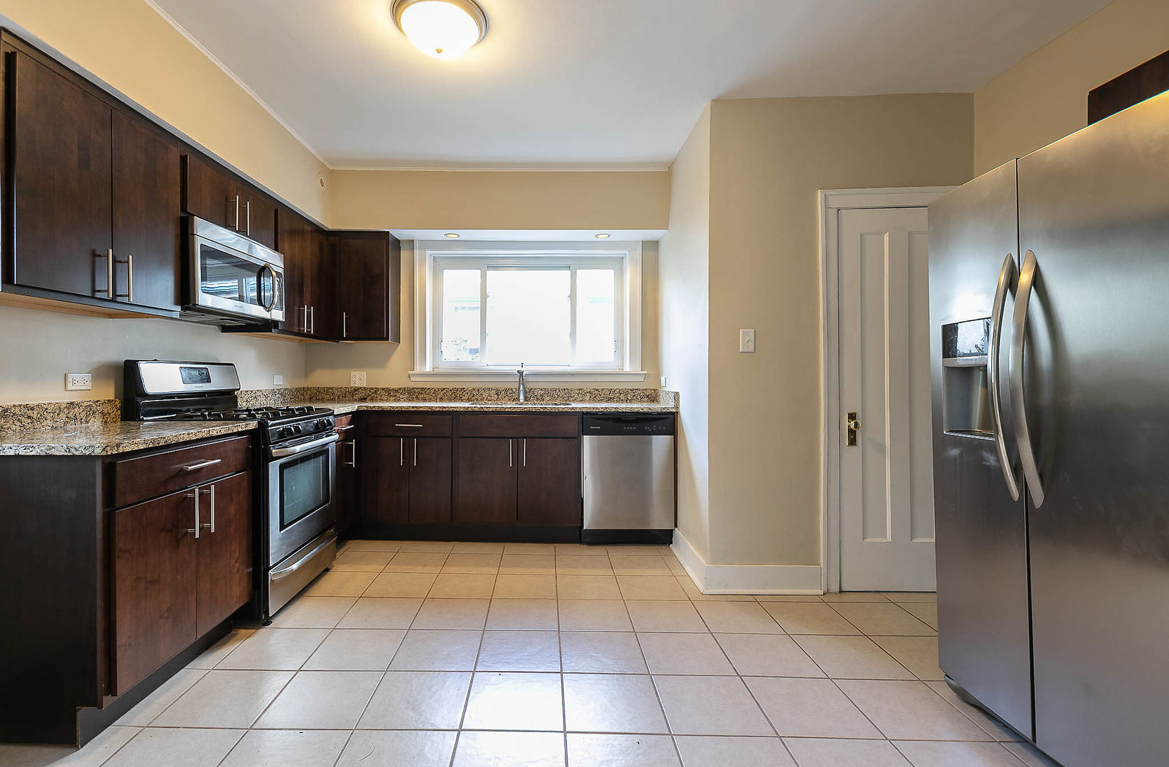 452 Loudon Road Riverside, IL 60546 - Photo 2 of 28 a large kitchen with granite countertop a stove top oven a sink dishwasher and a refrigerator