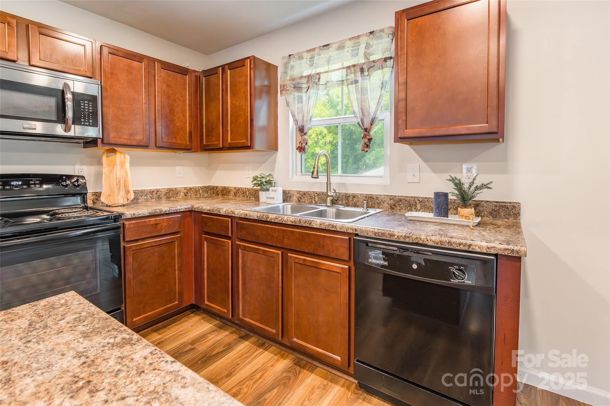 1128 Tangle Ridge Drive Southeast Concord, NC 28025 - Photo 6 of 27 a kitchen with stainless steel appliances granite countertop a sink stove and microwave