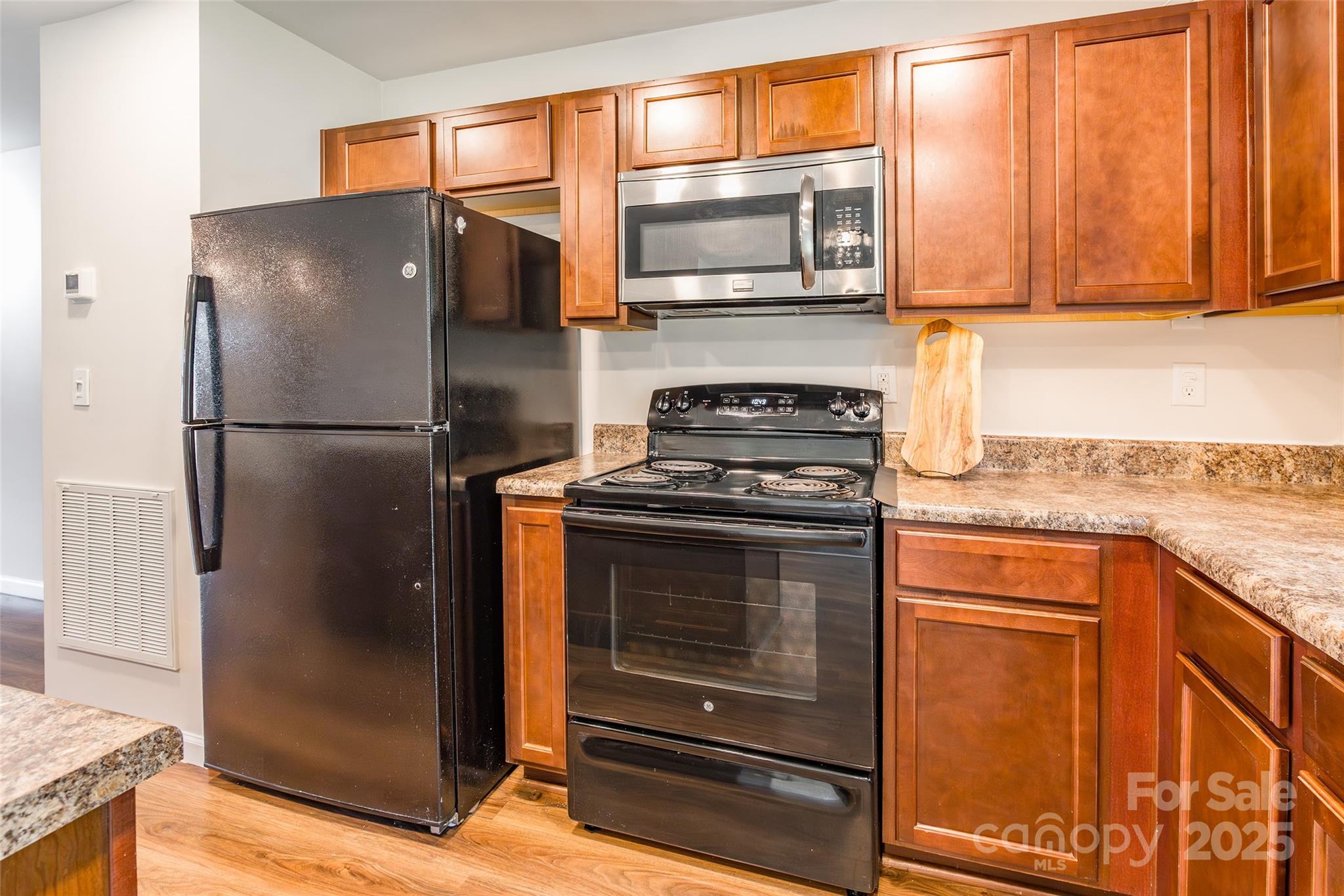 1128 Tangle Ridge Drive Southeast Concord, NC 28025 - Photo 7 of 27 a kitchen with granite countertop a refrigerator stove and microwave
