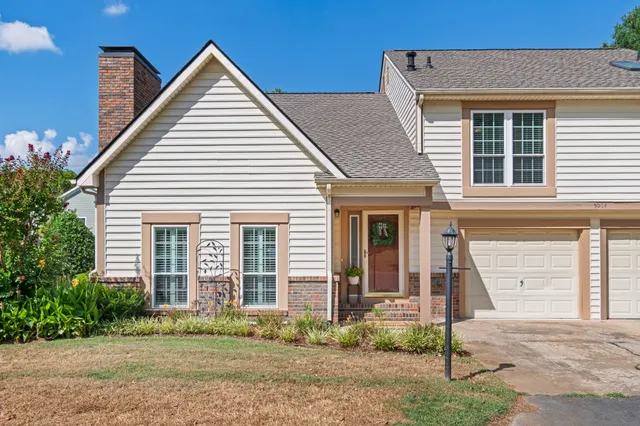 a view of a house with a yard and potted plants