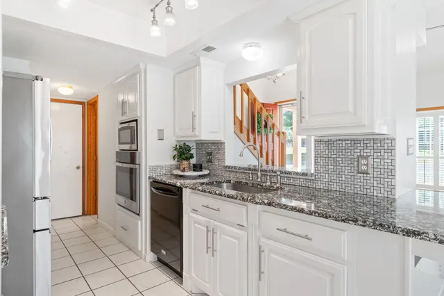 a kitchen with stainless steel appliances granite countertop a sink and cabinets