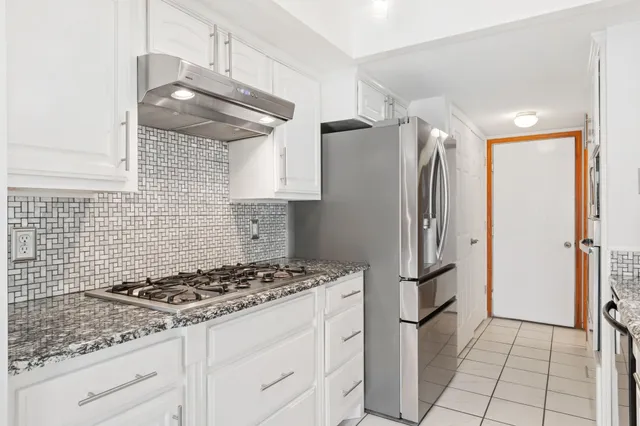 a kitchen with stainless steel appliances granite countertop a refrigerator and a stove top oven
