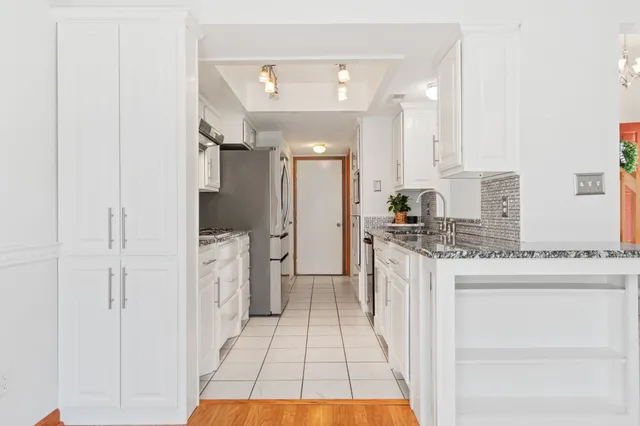 a kitchen with a sink refrigerator and cabinets