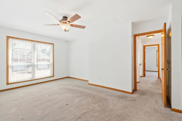 an empty room with fan and windows