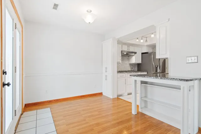 a room with a bed and a view of kitchen