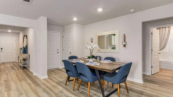 a kitchen with stainless steel appliances kitchen island granite countertop a stove a sink a refrigerator and white dining table with wooden floor