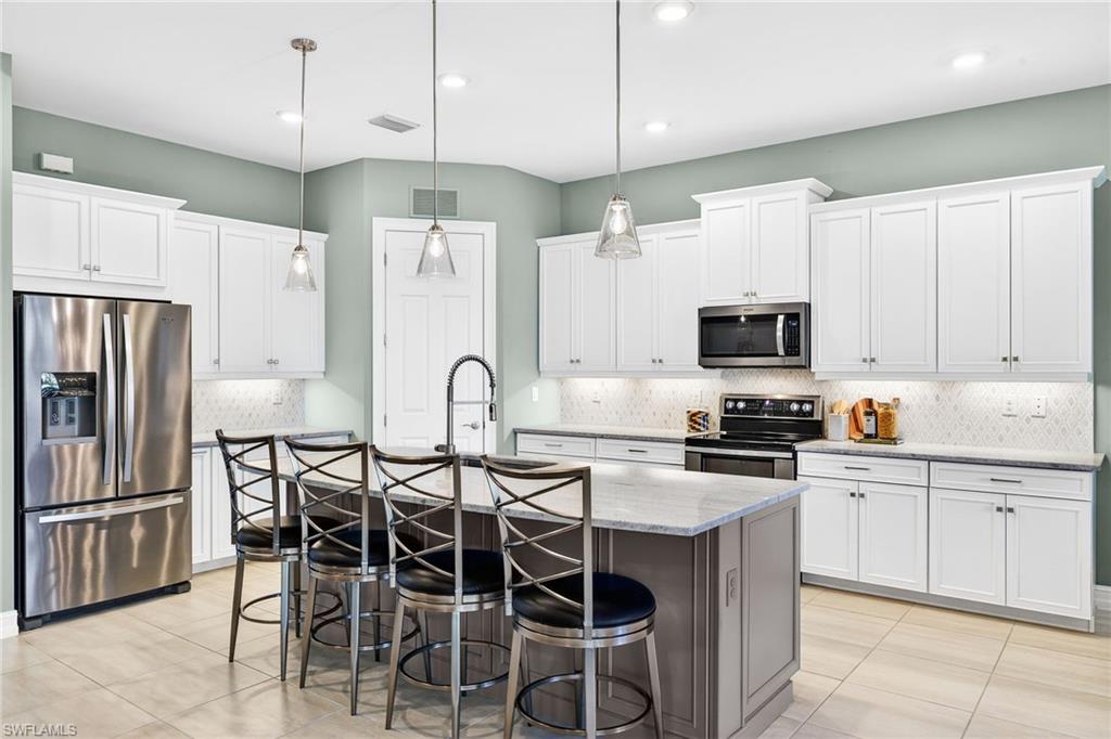 14523 Kelson Circle Naples, FL 34114 - Photo 11 of 50 a kitchen with stainless steel appliances a stove sink microwave and refrigerator