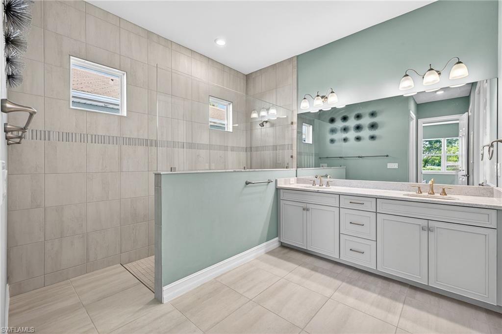 14523 Kelson Circle Naples, FL 34114 - Photo 18 of 50 a spacious bathroom with a sink mirror and a shower
