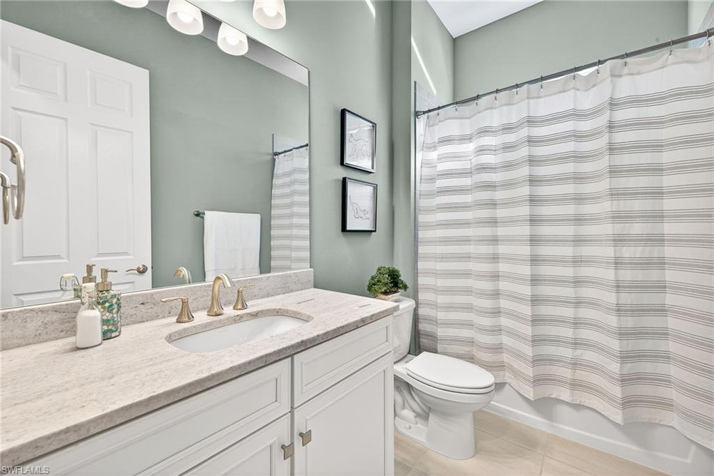 14523 Kelson Circle Naples, FL 34114 - Photo 21 of 50 a bathroom with a granite countertop toilet sink and mirror