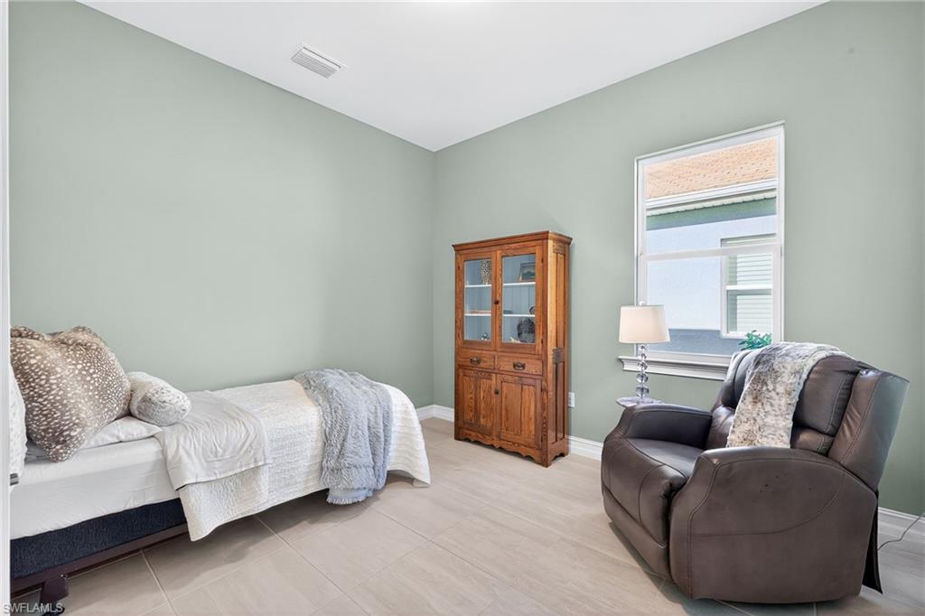 14523 Kelson Circle Naples, FL 34114 - Photo 23 of 50 a bedroom with a bed and couch