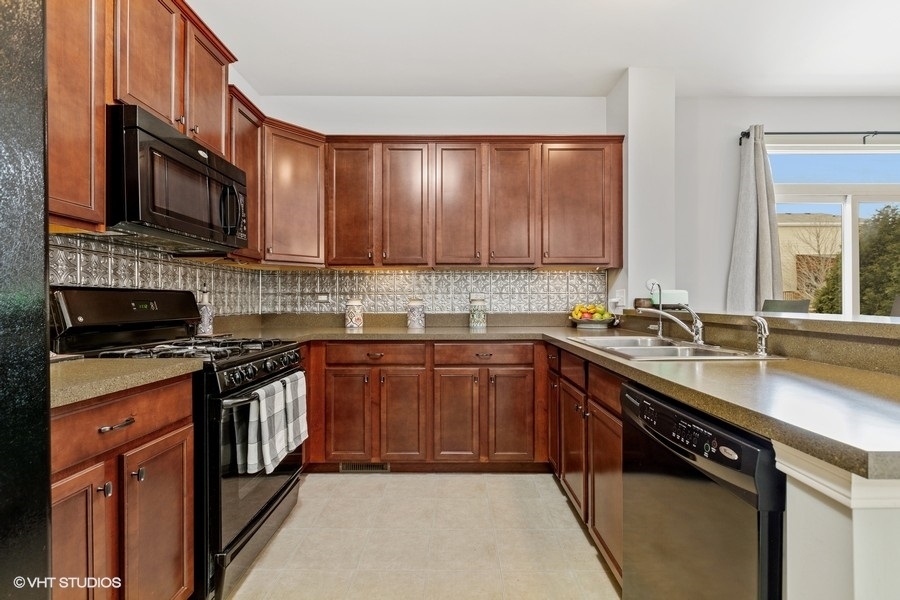 1825 Powers Road Woodstock, IL 60098 - Photo 3 of 18 a kitchen with stainless steel appliances granite countertop a stove a sink and a microwave