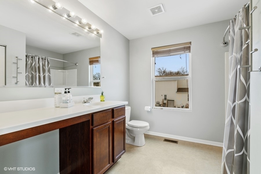 1825 Powers Road Woodstock, IL 60098 - Photo 9 of 18 a bathroom with a double vanity sink mirror and toilet