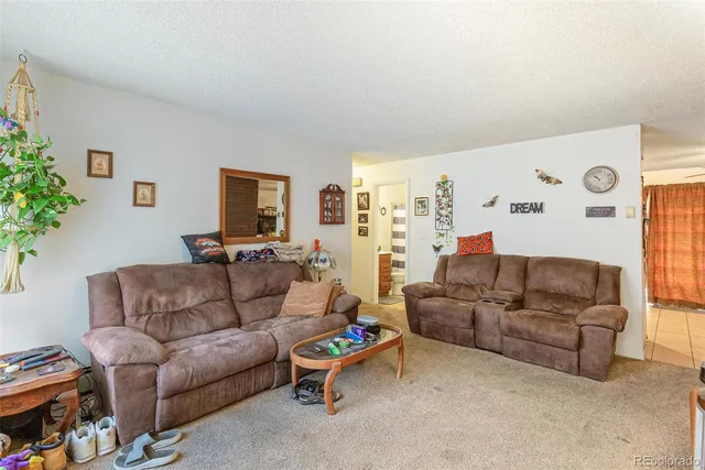 a living room with furniture a window and a flat screen tv