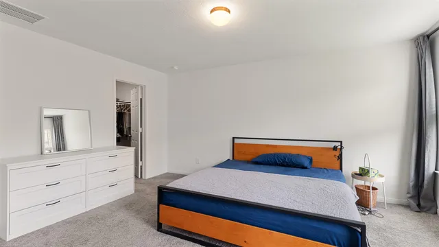 a bedroom with a bed and a dresser