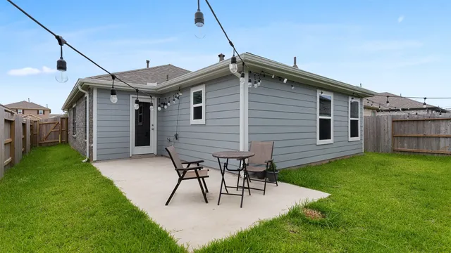 a backyard of a house with table and chairs