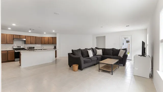 a living room with furniture and kitchen view