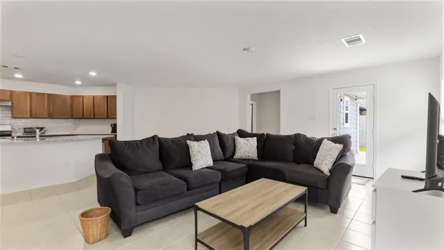 a living room with furniture and a view of kitchen