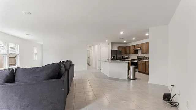a living room with furniture and a refrigerator