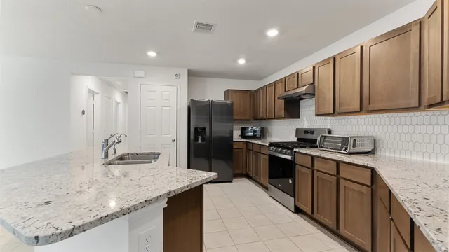 a kitchen with stainless steel appliances granite countertop a sink stove and refrigerator