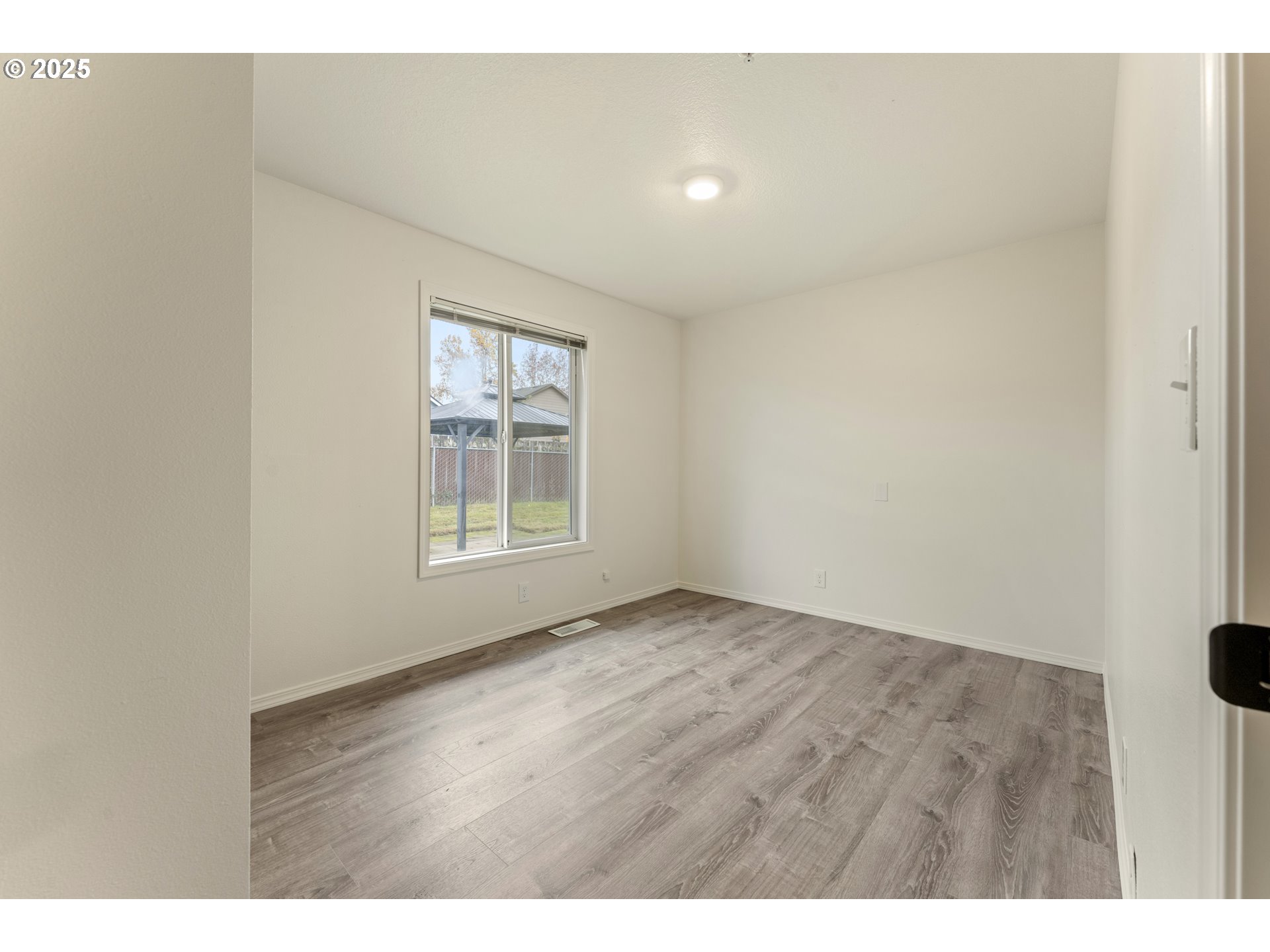 1530 Southeast 5th Street Gresham, OR 97080 - Photo 18 of 39 a view of an empty room with wooden floor and a window