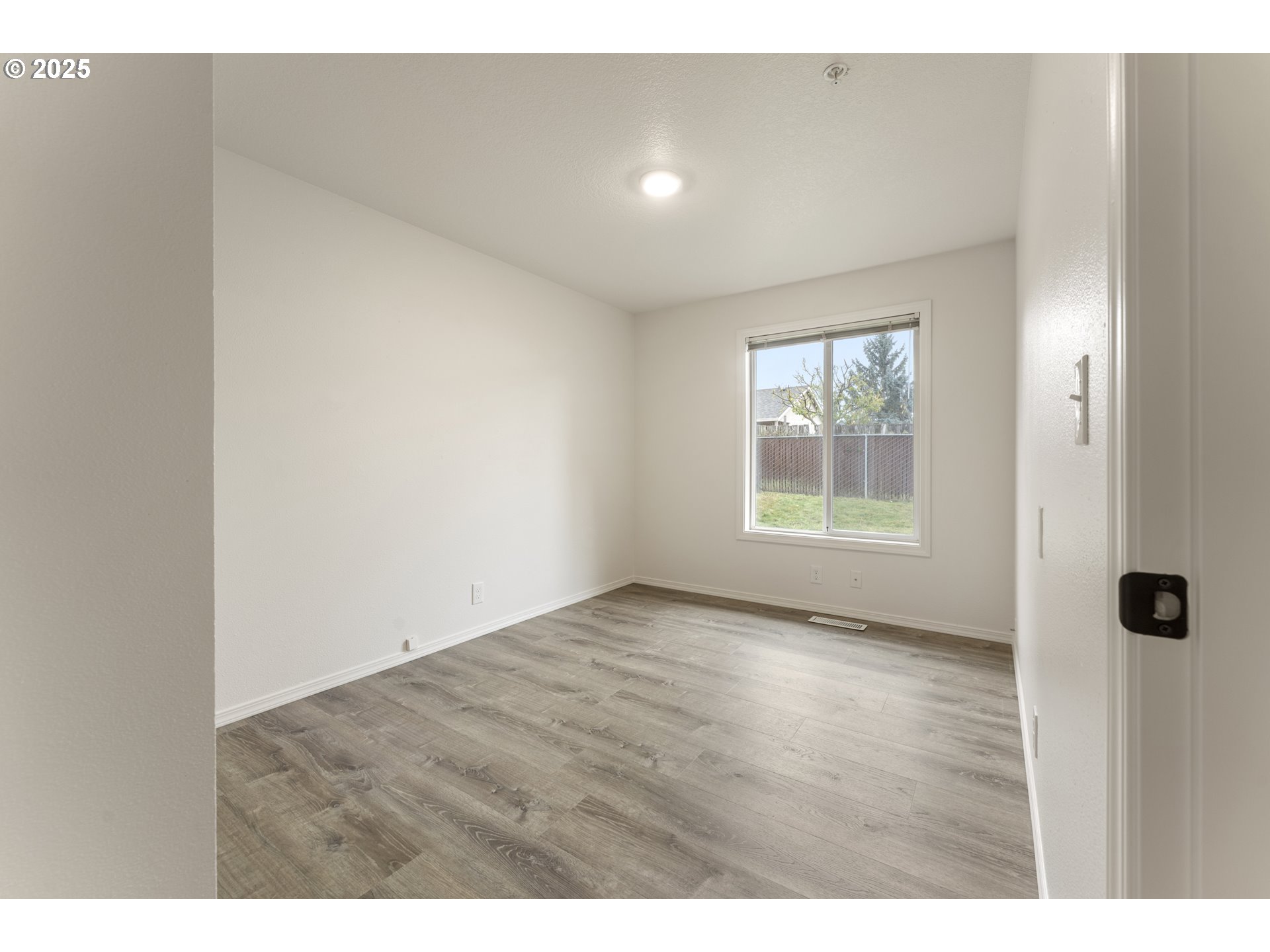 1530 Southeast 5th Street Gresham, OR 97080 - Photo 20 of 39 a view of an empty room with wooden floor and a window