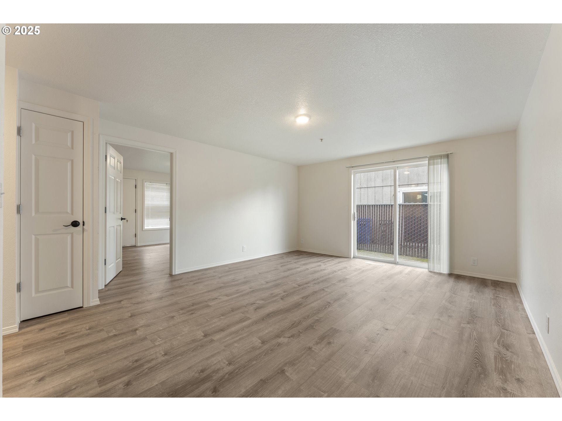 1530 Southeast 5th Street Gresham, OR 97080 - Photo 7 of 39 a view of an empty room with wooden floor and a window